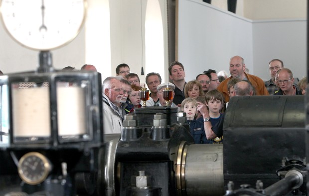Eine Gruppe von Besuchern an der Dampfmaschine in der Maschinenhalle der Zeche Hannover. Foto: Walter Fischer