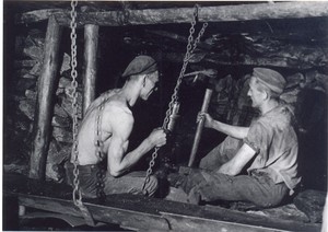 Zwei Bergleute bei der Arbeit unter Tage.