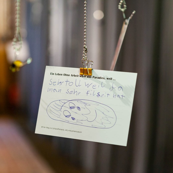 Eine beschriftete Postkarte hängt in der Ausstellung. (vergrößerte Bildansicht wird geöffnet)