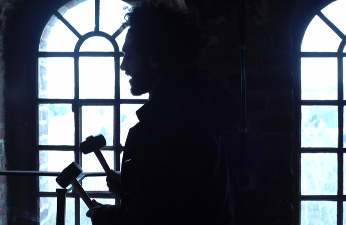 Singender Mann steht im Profil vor einem Fenster im Malakowturm