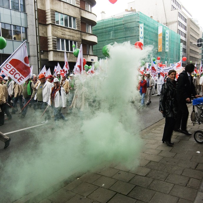 Demonstrierende Minenarbeiter laufen eine Straße entlang, im Vordergrund ist grüner Rauch zu sehen (vergrößerte Bildansicht wird geöffnet)