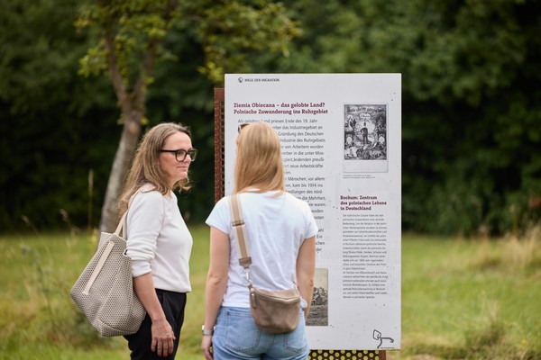 Besucherinnen vor einer Tafel